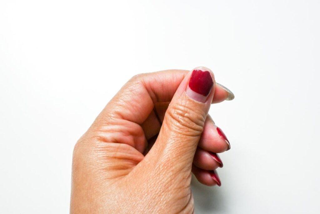 uñas con esmalte rojo desgastado manicura clásica vs semipermanente