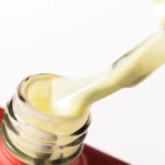 Detalle de la textura amarillo claro de Rubber Base NAILSUP Nauru 24 en el frasco abierto.