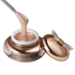 Tarro abierto de gel NAILSUP B14 Champagne de 15 g con una espátula mostrando su textura beige con brillo fino.