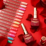 Muestrario de tonos NAILSUP Sapphire Flakes con escamas brillantes junto a un frasco de base rubber sobre fondo rojo